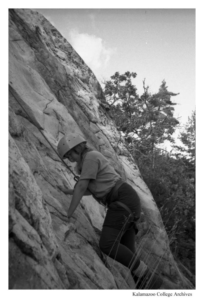 Photo of an individual beginning to climb a rock face.