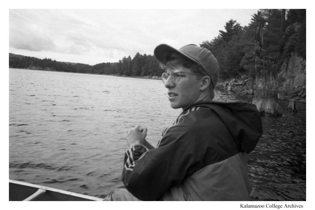 Individual with glasses pauses mid-row. 