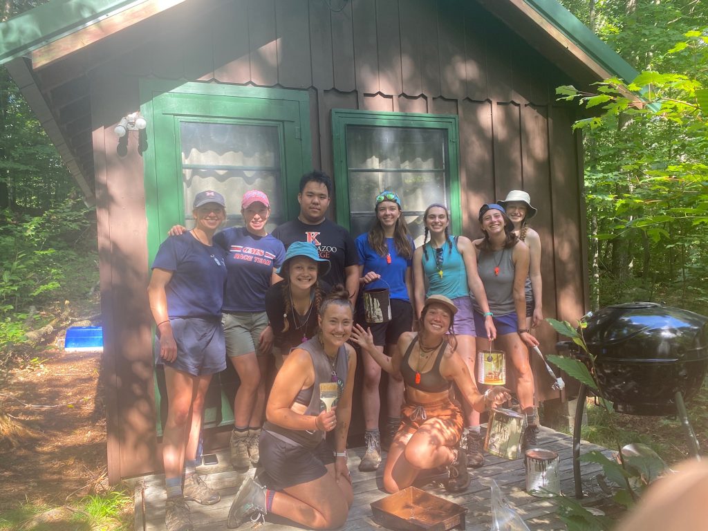 Participants and leaders paint cabins as a part of service. 