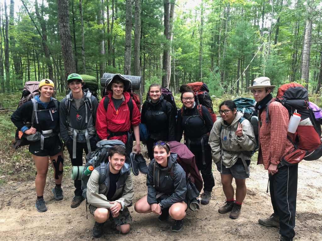 Session 2 participants smile as they get ready for the backpacking portion of program.