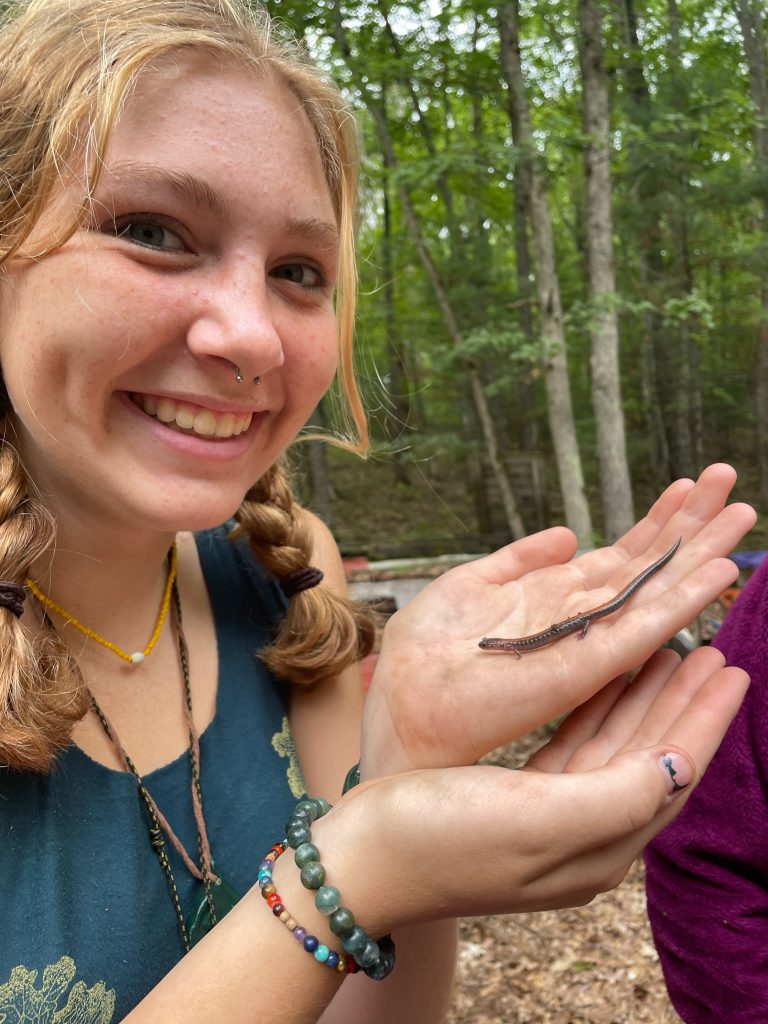 Participant caught a newt and is showing it to the camera. 