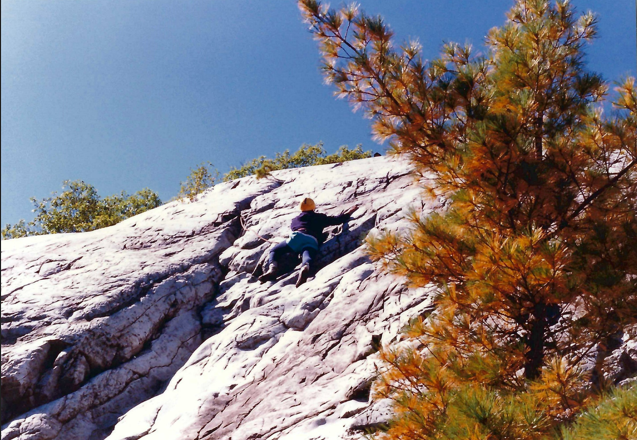 Climber halfway to the top of a rock-face. 