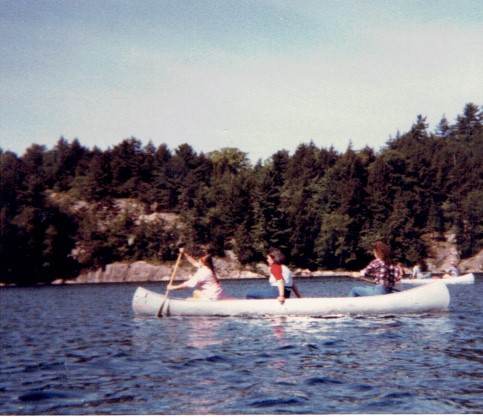 Two canoes paddle through a river. 