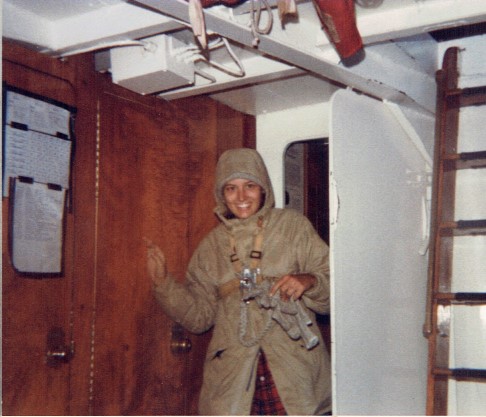 A photo of a young woman smiling below deck. 