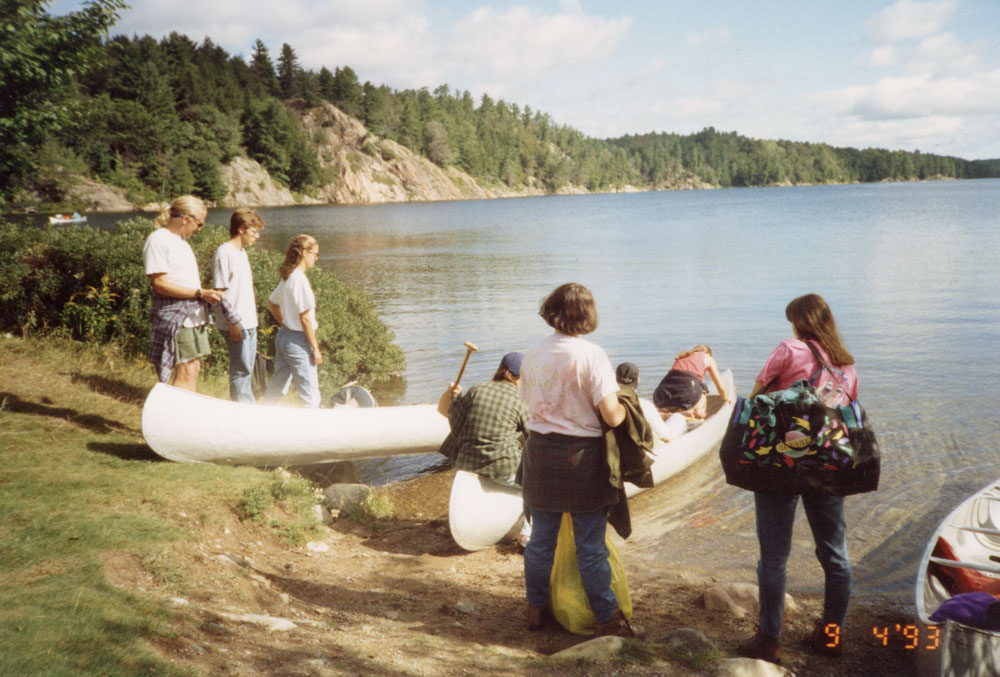 A group stands at the edge of the water about to take off.